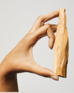 Hand mit Sandelholzstück als Symbol für die Basisnote von Tommy Girl