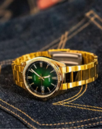 Goldene Casio MTP-1302PGC-3AVEF Herrenuhr mit grünem Zifferblatt auf einer Jeans liegend